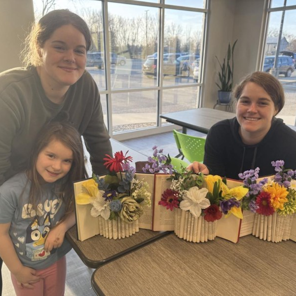 Three patrons with folded book art creations