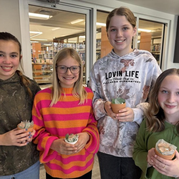 Four youth holding sea glass succulent creations